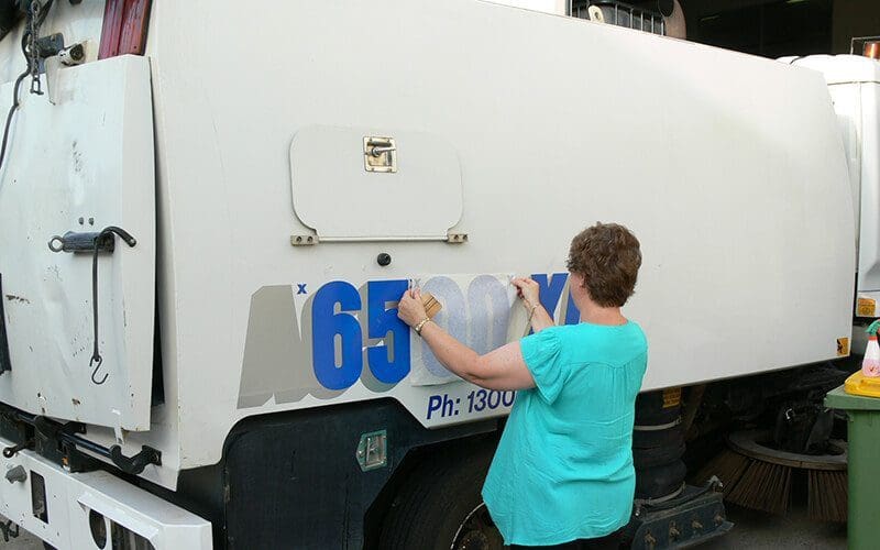Applying Stickers To Road Sweeper - Wombat Sweepers